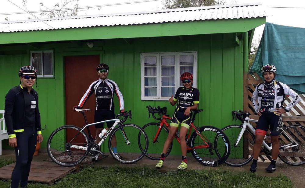 Ciclistas con sus bicicletas frente a una de las cabañas