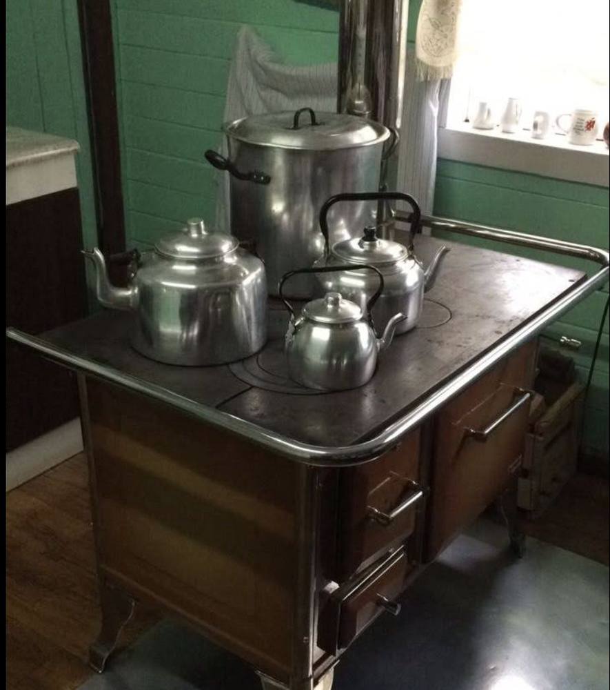 Cocina a leña antigua con teteras de aluminio